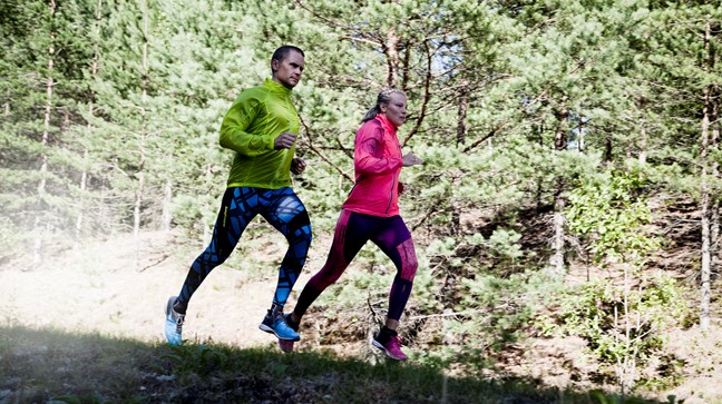 Två löpare i skogen.
