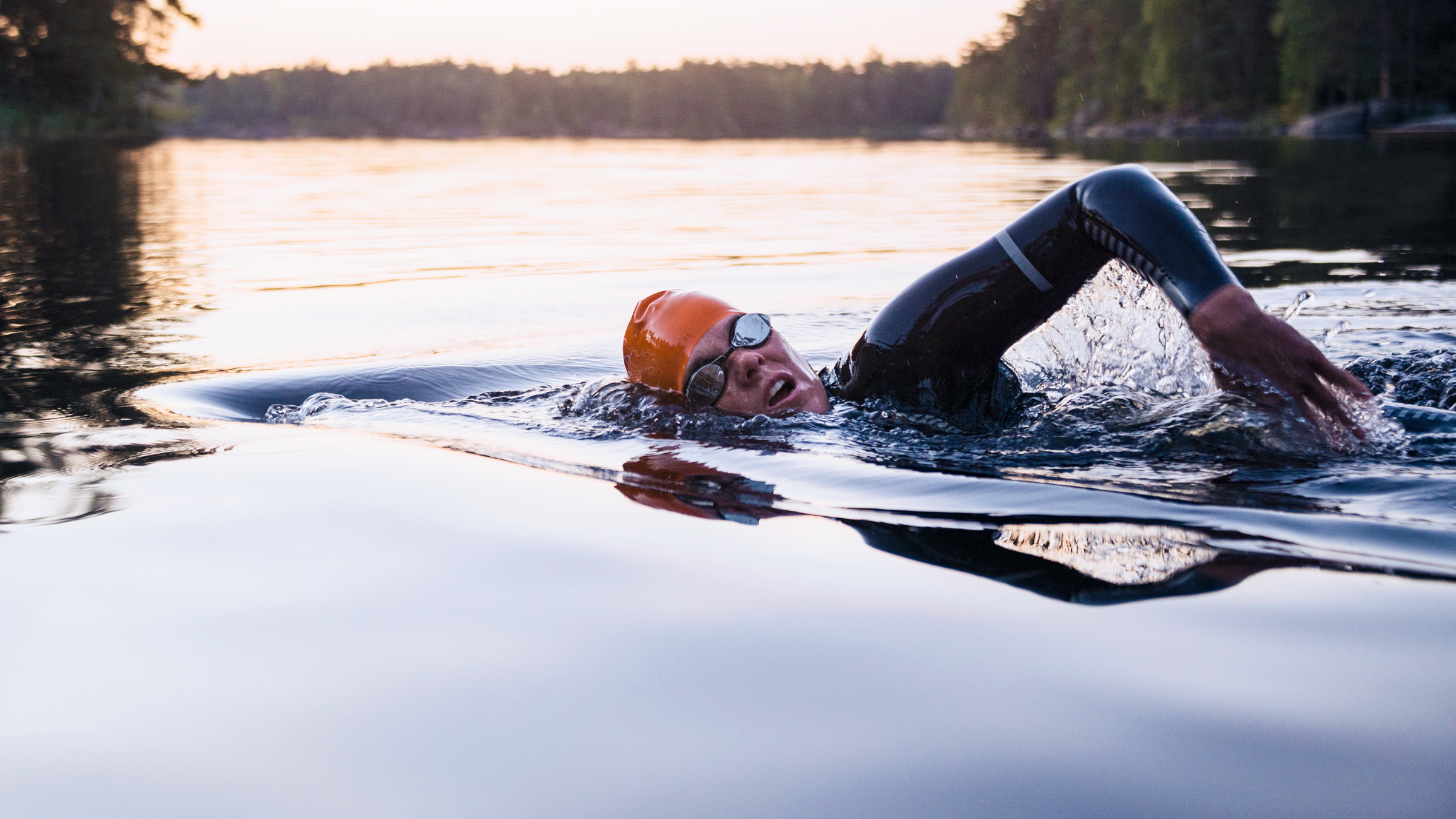 Simmar med våtdräkt i älven.
