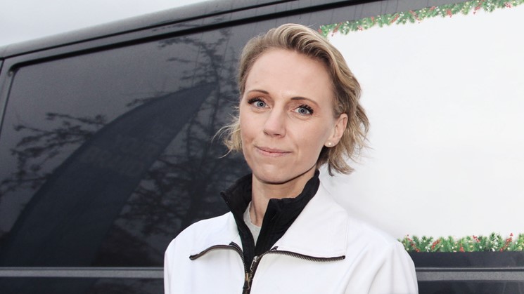 Madelene Lagerqvist står framför en av de bilar som ska rulla ut och leverera julklappar som avestaborna köpt lokalt via telefon.